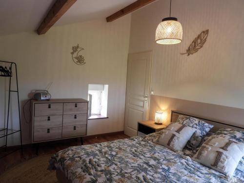 a bedroom with a bed and a dresser and a lamp at Les chaillées in Saint-Romain-en-Jarez