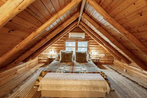 a bedroom in a log cabin with a bed at Fawn Hill Elevated Log Cabin w Year-Round Pool in Phoenicia