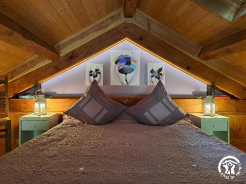a bedroom with a bed with two night stands and two lamps at Moulin de Record in Ferrières