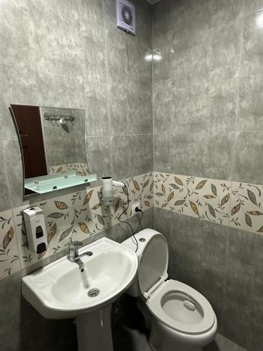 a bathroom with a toilet and a sink at Guest House Mukha in Akhaldaba