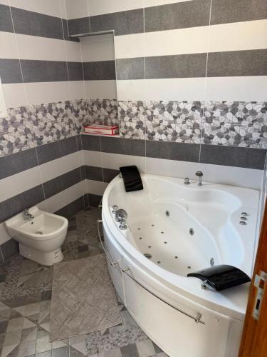 a bathroom with a white tub and a toilet at Appartement de luxe, Résidence les 5 étoiles, Bizerte in Zarzouna
