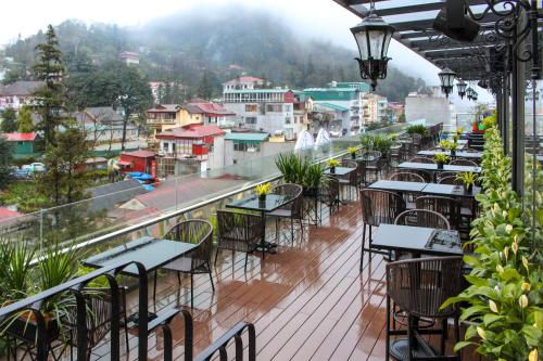 a balcony with tables and chairs and a view of a city at Hotel Sapa Square, Affiliated by Meliá in Sapa