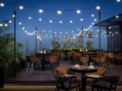 a restaurant with tables and chairs on a patio at night at Hotel Sapa Square, Affiliated by Meliá in Sapa