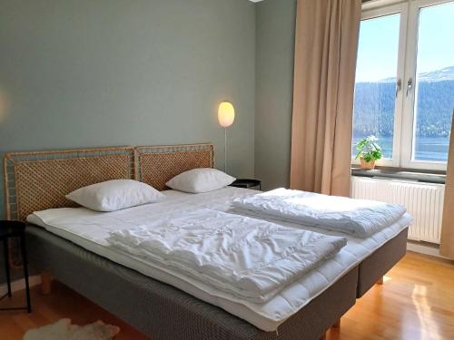 a bedroom with a bed with white sheets and a window at Lakeview 4BR with Sauna & EV Parking in Åre