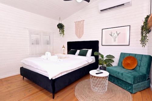 a bedroom with a bed and a green chair at דאוס האוס - דירות אירוח מודרניות ושקטות in Eilat