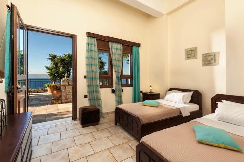 a bedroom with two beds and a view of the ocean at Villa Thalassea in Kalami