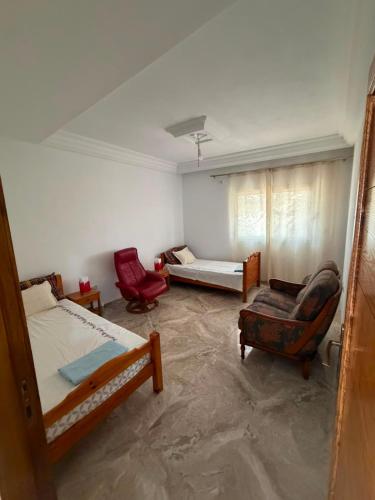 a room with two beds and two chairs in it at Appartement de luxe, Résidence les 5 étoiles, Bizerte in Zarzouna