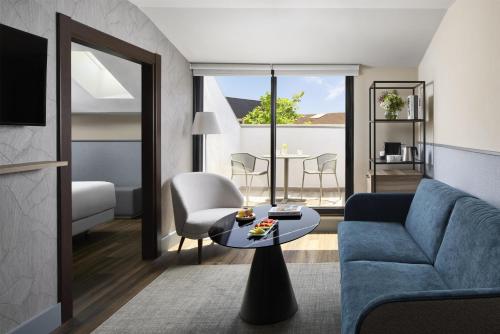 a living room with a couch and a table at NH Ciudad de Santander in Santander