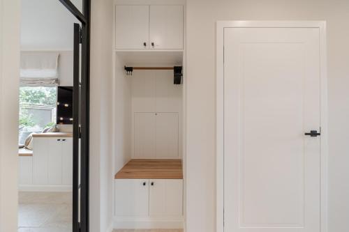 a kitchen with white cabinets and a sliding door at Dolle's Hüs in Wenningstedt