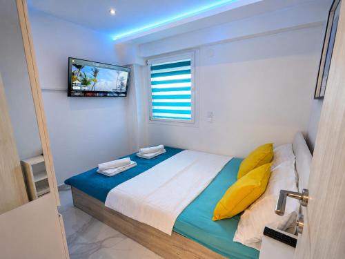 a bedroom with a bed with a television on the wall at D4 Apartments Paralia No-5 in Paralia Katerinis