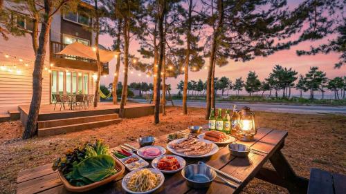 a wooden table with plates of food on it at Goseong Omaju Pension in Goseong