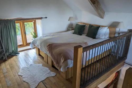 a bedroom with a large bed and a window at 1 Bed Barn - Sleeps 2 - Pool - Garden - Bbq in Taunton