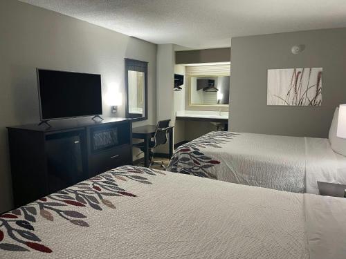 a hotel room with two beds and a flat screen tv at Red Roof Inn Helen, GA - Downtown in Helen