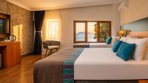 ein Hotelzimmer mit zwei Betten und einem Fenster in der Unterkunft Qinn Hotels in Antalya
