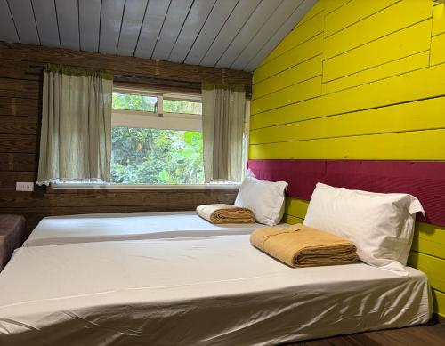 a bed in a room with a yellow and purple wall at A-HOME in Jiufen