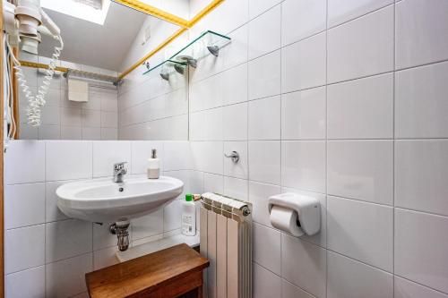 a bathroom with a sink and a toilet paper dispenser at Apto rurales y habitaciones MONTE CAORU - CABRALES apartahotel in Arenas de Cabrales