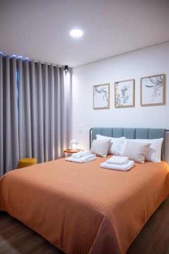 a bedroom with a large bed with orange blanket at La Maison de Ré in Vila Real