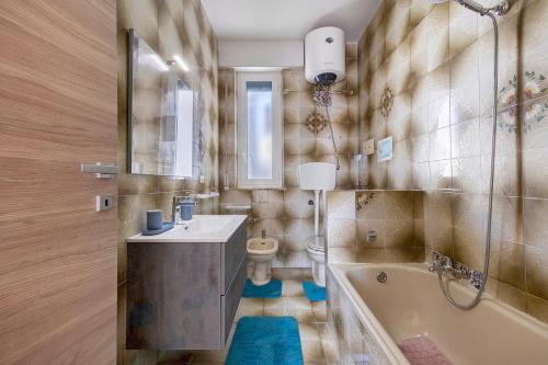 a bathroom with a tub and a sink and a toilet at The Nice Bright House in Palermo