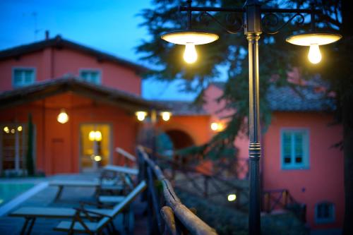 a street light in front of a house with benches at Agriturismo Villa Le Vigne in Montevarchi