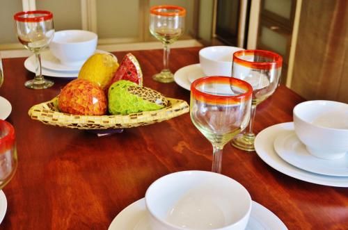 Una mesa de madera cubierta con platos y copas de vino. en Arrecifes Suites, en Puerto Morelos