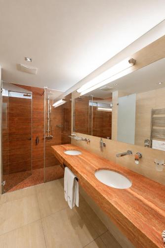 a bathroom with two sinks and a shower at Antonie Hotel****superior in Frýdlant