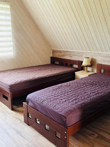 two beds in a room with a attic at Ezermala in Dagda