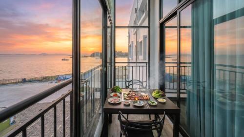 a table with food on a balcony with a view of the ocean at Yeosu Arungeorida Ocean View Pension in Yeosu