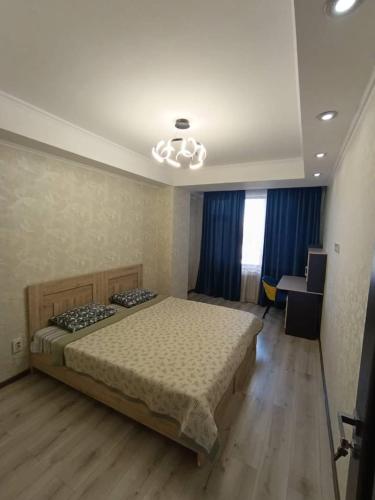 a bedroom with a bed and a desk in it at Urban in Bishkek