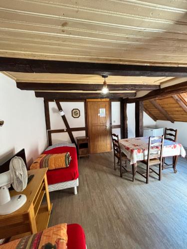a room with a bed and a table and chairs at Chambres d'hôtes chez Adam 