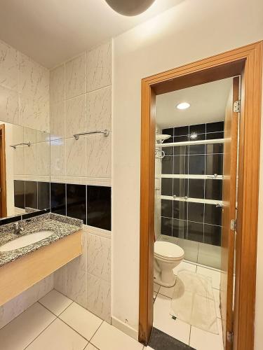 a bathroom with a toilet and a sink and a shower at Pontal do Lago Flat Residence, aproveite dias incríveis em família às margens do lago Corumbá in Caldas Novas