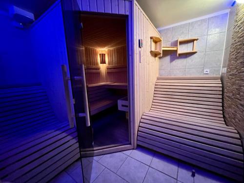 a room with benches in a room with blue lights at Chata Hubertka Krkonoše in Vítkovice