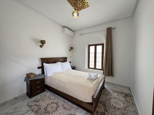 a bedroom with a bed and a window at Riad Ba brahim in Rabat