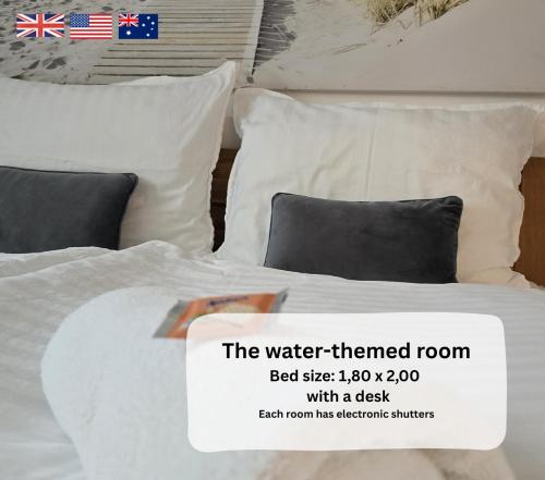 a white bed with pillows and a sign on it at Dreamly Suites Oslip in Oslip
