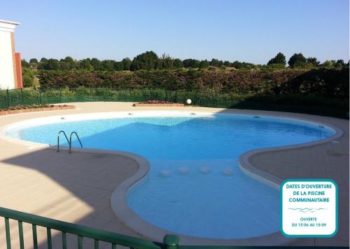 a large swimming pool with a sign in front of it at Maison proche Golf plage et piscine à Pornic in Pornic