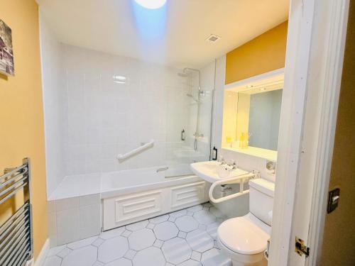 a white bathroom with a sink and a toilet at Wrexham Llyndir Hotel by Belvilla in Rossett