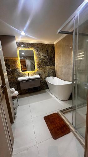 a bathroom with a tub and a sink at Residence 541 Apartments and Suites in Abuja