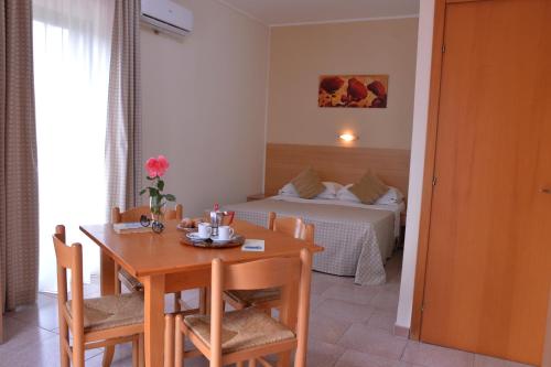 a room with a table and a bedroom with a bed at Villaggio Artemide in Giardini Naxos