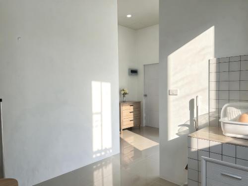 a white bathroom with a sink and a mirror at เอกสิริ รีสอร์ต in Amphoe Tha Chana