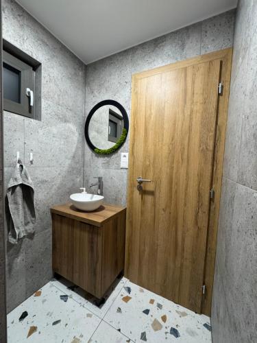 a bathroom with a wooden door and a sink at Chata Slovena in Novoť