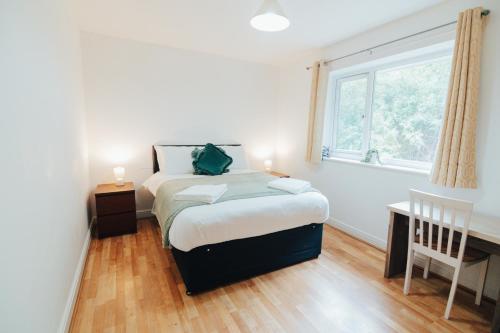 a small bedroom with a bed and a window at The Coastal Breeze in Porthmadog