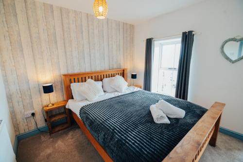 a bedroom with a bed with two white pillows on it at The Graigfryn Hideaway in Amlwch
