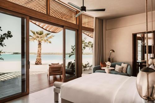 a bedroom with a bed and a view of the ocean at Miraval The Red Sea All Inclusive Adults Only in Ḩanak