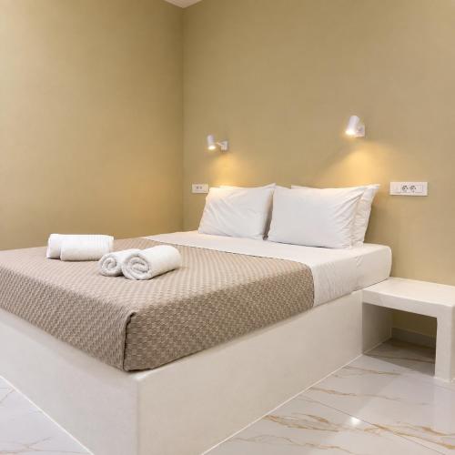 a bedroom with a bed with towels on it at Pelekouda Coastal Apartments in Pollonia