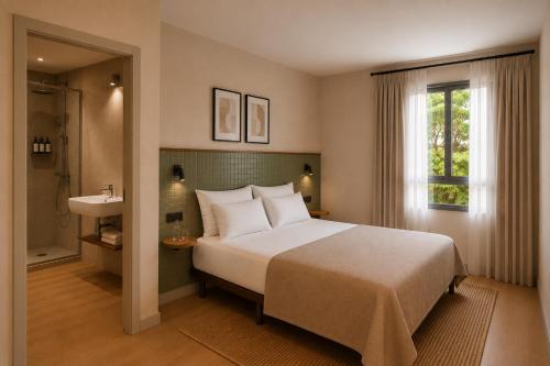 a bedroom with a large bed and a bathroom at Colectia Hotel Santa Lucía in Seville