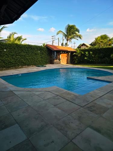 a swimming pool with blue water in a yard at Ventos e Dunas Cumbuco in Cumbuco
