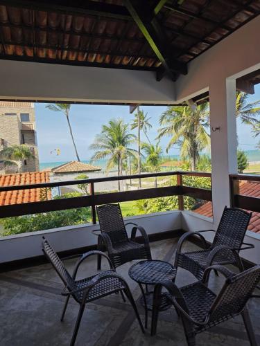 a balcony with chairs and a table and a view of the ocean at Ventos e Dunas Cumbuco in Cumbuco