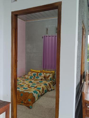 a bedroom with a bed and a door with a mirror at Uoemah gunung baturaden in Baturaden