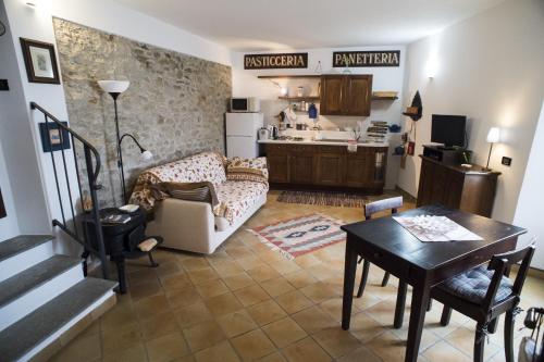 uma sala de estar com um sofá e uma mesa em Archi del '400 Appartamento em Barolo