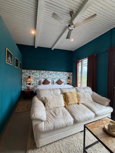 a living room with a white couch and a bed at MATANAI HOUSE X THHP - The Deck Villa Mukteshwar - 2 Bedroom Bonfire & BBQ in Mukteshwar