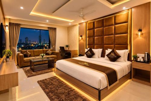 a hotel room with a large bed and a couch at Hotel Bellwood Inn Near IGI Delhi International Airport in New Delhi